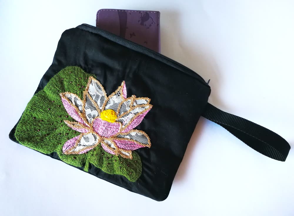 Finished black purse with an embroidered pink lotus flower and green leaf